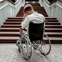 Mand i kørestol kan ikke komme op ad trappe på grund af manglende rampe.